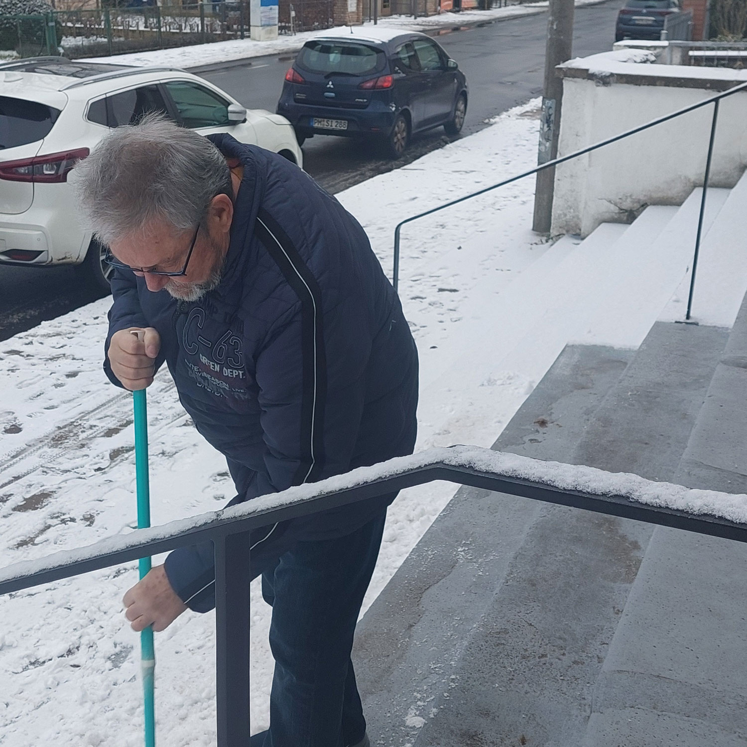 Richi fegt Schnee von der Eingangstreppe
