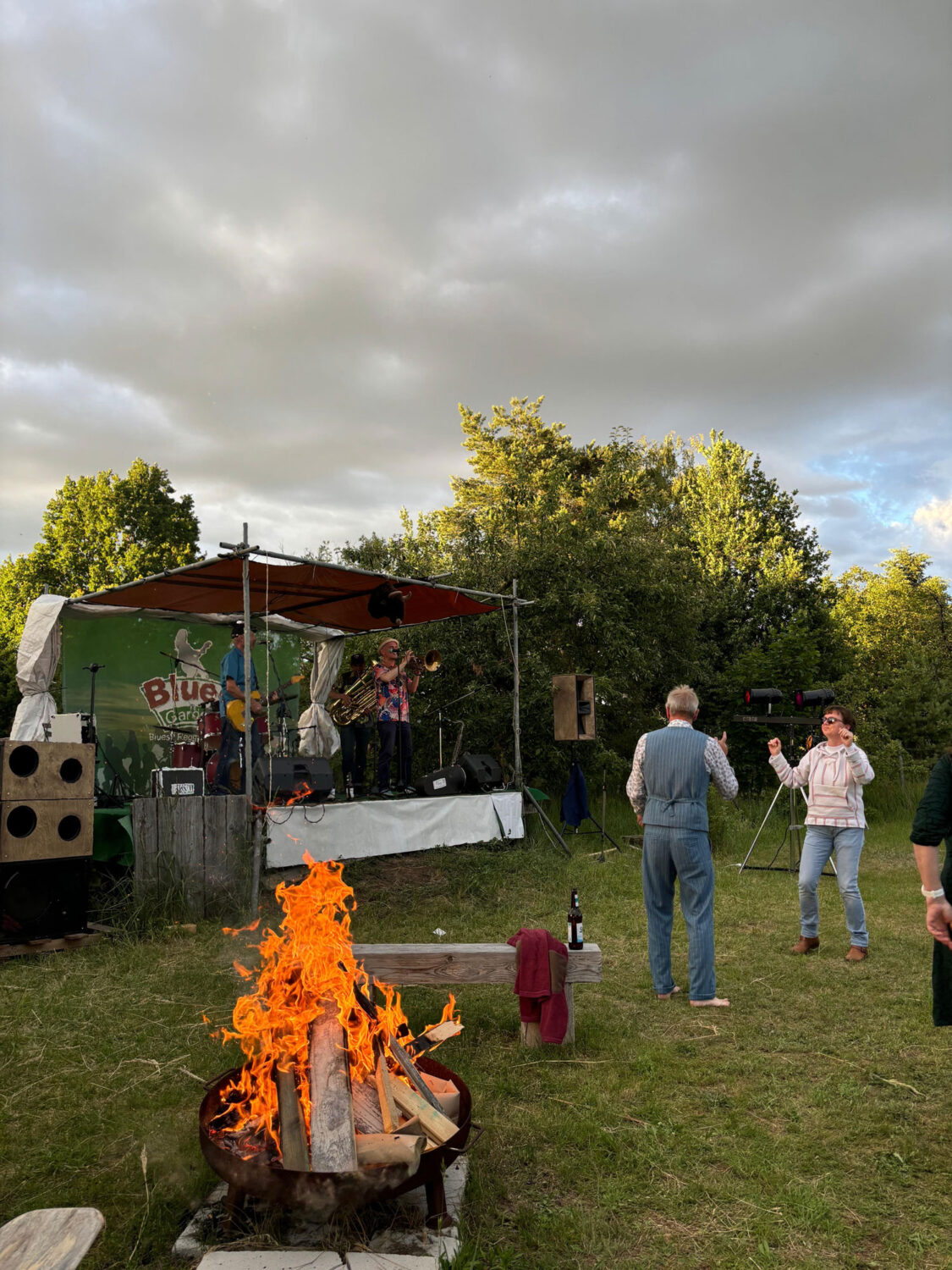 Leuchtendes Feuer in der Schale mit Bühne und Tanzenden