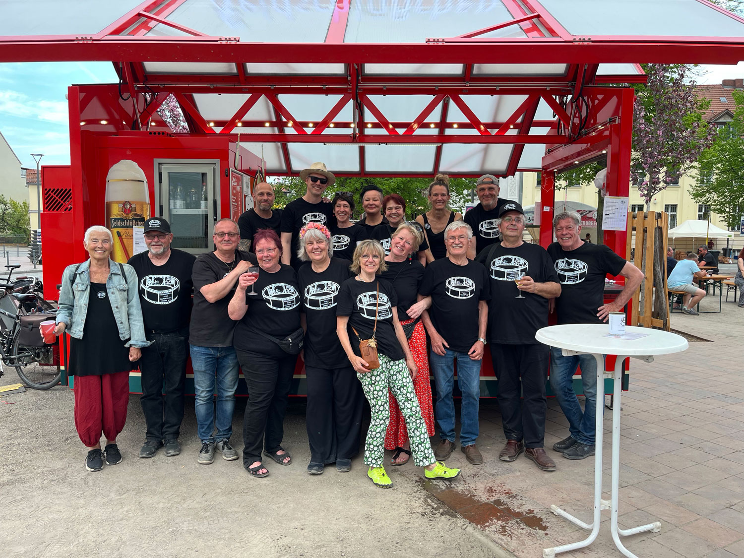 Gruppenbild mit 17 Personen vor dem Getränkewagen